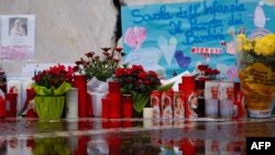 教宗方济各因肺炎住院,人们在罗马杰梅利医院前摆放蜡烛和鲜花为教宗祈福。(法新社:2025年3月1日)