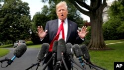 在前往纽约之前,美国总统川普在微风中在白宫南草坪对记者讲话。(2018年5月23日)
