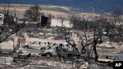 2023年8月13日星期日,夏威夷拉海纳的一个社区可见房屋和车辆被毁。此前几天前一场致命的野火造成了严重损失。 (美联社图)