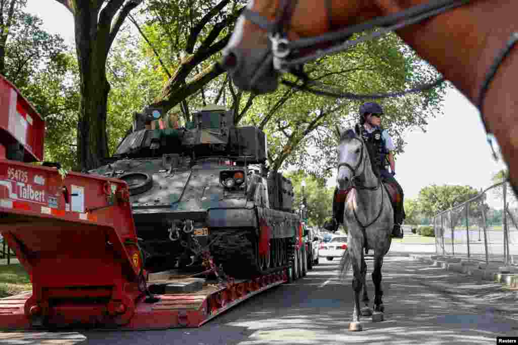 在首都华盛顿,一名美国国家公园骑警经过一辆布雷德利装甲步兵战车。(2019年7月3日)