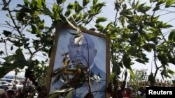 布隆迪总统的支持者举着总统的相片等待总统回首都(2015年5月15日)