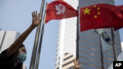 资料照:在香港和中国旗帜下香港抗议者伸出手掌表示五大诉求缺一不可。