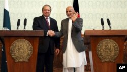Afghan President Ashraf Ghani, right, shakes hands with Pakistani Prime Minster Nawaz Sharif during a joint press conference at the presidential palace in Kabul, May 12, 2015.