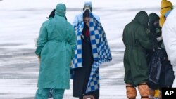 身穿防护服的俄罗斯医护人员在秋明附近的一个机场迎接俄罗斯军机从武汉撤回的侨民。(2020年2月5日)