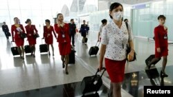 资料照:香港国泰航空公司的空姐在2003年中国非典疫情期间戴口罩上班。(2003年5月15日)