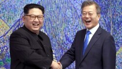 Lãnh tụ Triều Tiên Kim Jong Un (trái) bắt tay Tổng thống Hàn Quốc Moon Jae-in cho báo giới chụp hình bên trong Nhà Hòa bình tại làng đình chiến Panmunjom trong Khu Phi quân sự, ngày 27 tháng 4, 2018.
