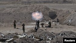 Quân đội Iraq và các chiến binh Shia, bên ngoài thành phố Falluja, pháo đạn súng cối về hướng của nhóm Nhà nước Hồi giáo, 19/5/15