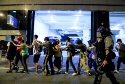 香港理工大学的抗议学生在警察的押送下离开校园。(2019年11月18日)