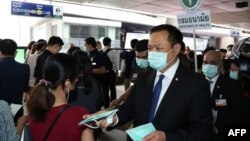 泰国公共卫生部长阿努丁在曼谷的一个高架轻轨车站发放疫情防护口罩。(2020年2月7日)