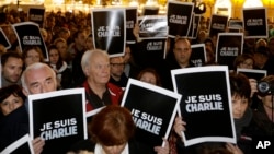人们聚集在德国柏林的勃兰登堡门,举着“我是查理”的标语,声援遭枪击的法国《查理周刊》。(2014年1月7日)