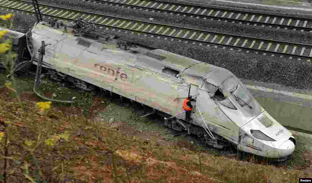 Một giới chức kiểm tra động cơ xe lửa giữa đống đổ nát của vụ tai nạn gần Santiago de Compostela, miền Bắc Tây Ban Nha, ngày 25/7/2013.