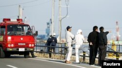 救火队员和福岛当地居民在海啸预警之后观察海水水位(2016年11月22日)