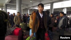 2月1日,在中国南方的东莞市火车东站,民工们载满了行李,排队等待搭载他们回家过新年的列车。