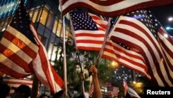 香港抗议民众在游行期间挥舞美国国旗。(2019年10月14日)