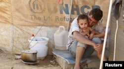 Hai cha con người Syria tại trại tị nạn Al Zaatri ở thành phố Mafraq của Jordan gần biên giới Syria