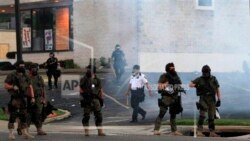 2014年8月11日,密苏里州弗格森,身着防暴装备的警察试图驱散人群。8月9日,在为手无寸铁的18岁黑人男子迈克尔·布朗(Michael Brown)守夜后,人群抢劫和焚烧商店,破坏车辆,嘲弄警察。(美联社图片)