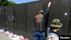 Thành viên trong nhóm 'Rolling Thunder' đặt tay lên bức tường đá hoa cương đen của Đài tưởng niệm Cựu chiến binh Việt Nam ở thủ đô Washington, ngày 25/5/2014.