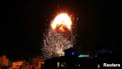 以色列空袭期间,加沙市一座建筑上方冒起浓烟和烈焰。(2021年5月17日)