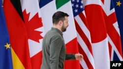 乌克兰总统泽连斯基在意大利普利亚地区出席G7峰会期间走过与会国旗帜。(2024年6月13日)