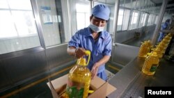 2018年7月4日,在中国山东省曲阜市,在粮油工业和进出口公司的工厂,工人把瓶装大豆油装箱,这些大豆油是用美国大豆制造的。