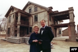 美国福音牧师葛培理和夫人钟路得在她在江苏省淮阴的出生地前留影。(1988年4月19日)