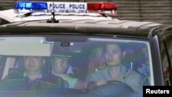 这张由日本共同社拍到的照片显示薄熙来坐在警车内离开济南中级人民法院。(2013年8月23日)