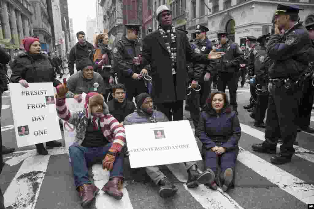 Police officers prepare to take New York City Councilman Jumaane Williams, center, into custody after he and others blocked traffic on Fifth Avenue outside Trump Tower in New York, Friday, Jan. 20, 2017, during a protest during President Donald Trump's inauguration. (AP Photo/Mary Altaffer)