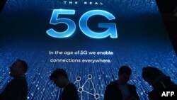 2019年电子消费展在拉斯维加斯会展中心举行,与会者在高通展台前排队等待5G展示。