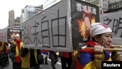 活动人士在台北一次集会中抬着假的棺木,悼念自焚的藏人(资料照片)