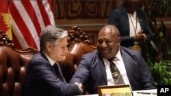 2023年5月22日,美国国务卿安东尼·布林肯(左)和巴布亚新几内亚国防部长温·巴克里·达基(右)在签署安全协议后握手。(美联社照片)