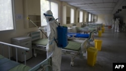 武汉第七医院的工人给一间曾经住过新冠病人的病房消毒,准备恢复正常接诊工作。(2020年3月19日)