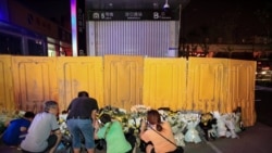 河南郑州市民在被黄色围栏围起来的地铁5号线车站前献花悼念水灾死难者。(2021年7月26日)