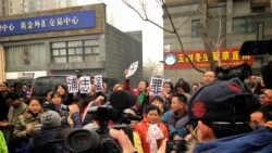 2015年12月22日,北京市二中院外面,支持者向国际媒体展示浦志强无罪的大字标语。(美国之音叶兵拍摄)