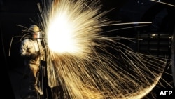 2018年1月18日,中国山东省青岛市的一名工人切割钢材。