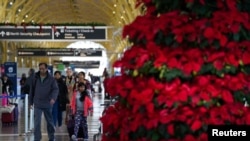 2022年12月20日，乘客在华盛顿里根国家机场走过。全国大部分地区的冬季风暴可能会导致圣诞节假期的旅行延误。（路透社照片）