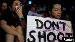 香港民众2019年6月14日举行集会支持6.12反对逃犯条例修法大游行的示威者,两名流泪的女子手持“不要开枪”的标语。