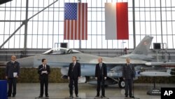 波兰军队军备总督查斯泽帕尼亚克将军、美国驻波兰大使斯蒂芬·马尔、波兰副总理兼国防部长谢莫尼亚克和其他官员在波兰波兹南的一处空军基地签署协议。(2014年12月11日 资料照片)