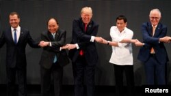 美国总统川普与东盟国家领导人以及俄罗斯总理梅德韦杰夫、澳大利亚总理特恩布尔以双臂交叉的东盟传统方式握手。(2017年11月13日)