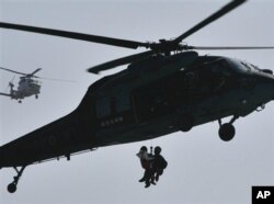 2011年3月13日,地震和海啸发生两天后,日本自卫队成员在日本北部救出一名灾民。