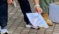 港澳办副主任张晓明等北京官员拒绝派代表接收社民连的请愿信,该会主席黄浩铭当场焚烧请愿信以示抗议 (美国之音/汤惠芸)