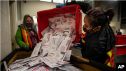 资料照片:2020年11月3日,选举工作人员在俄勒冈州波特兰市清空投票箱中的选票。(美联社照片)