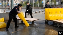 日前湖北省武汉市解除封锁，工作人员在移除道路上的障碍物。（2020年4月7日）