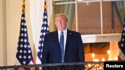 特朗普总统乘坐“海军陆战队一号”总统专用直升机沃尔·里德国家医疗中心返回白宫,站在杜鲁门阳台上。(2020年10月5日)