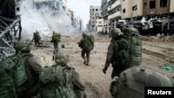 以色列国防部2023年12月18日发表照片显示,以色列士兵在加沙地带行进。