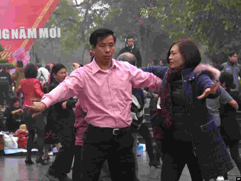 Những người biểu tình nghi chính phủ 'thuê' những người nhảy múa thể dục để ngăn chặn các ngã đường đến tượng đài Lý Thái Tổ ở thủ đô Hà Nội, ngày 16/2/2014.