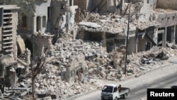 2016年8月18日,一辆卡车经过叙利亚阿勒颇市反抗力量控制区的残垣断壁。