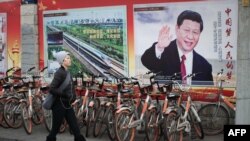 在北京的一面墙上展示的关于中国国家主席习近平、中国特色社会主义和四个自信的宣传画(2018年3月12日)。