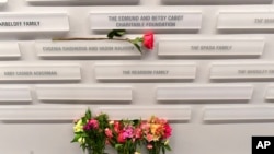 波士顿滑冰具乐部的纪念墙上,一朵玫瑰放在花式滑冰教练叶夫根尼娅·希什科娃和瓦迪姆·诺莫夫的名字旁边。(美联社:2025年1月30日)