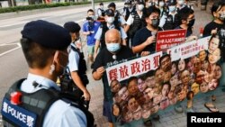 香港支持民主的抗议者在中国国庆当天,手举标语牌要求释放政治犯。(2021年10月1日)