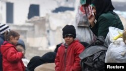 一个孩童和其他人一起等待从反政府武装控制的阿勒颇东部撤离（2016年12月16日）